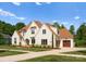 Beautiful exterior view of the white brick home, showcasing a three car garage and landscaped yard at 10201 Laurier Ln, Huntersville, NC 28078