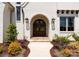 Close-up of the arched double front door, flanked by elegant lanterns and lush landscaping at 10201 Laurier Ln, Huntersville, NC 28078