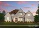 Charming two-story home with brick and neutral color, landscaped yard, and inviting arched entryway at 10201 Laurier Ln, Huntersville, NC 28078