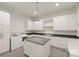 Well-equipped laundry room featuring white cabinets, modern appliances, a central island, and ample storage at 10201 Laurier Ln, Huntersville, NC 28078