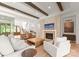Bright living room with exposed beams, white sofas, fireplace, and open access to other rooms at 10201 Laurier Ln, Huntersville, NC 28078