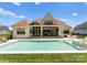 Gorgeous backyard with an in-ground pool, sun loungers, outdoor seating, and well-manicured lawn at 10201 Laurier Ln, Huntersville, NC 28078