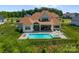 This backyard offers a pool, hot tub, large porch area, and a large grass area beyond the gated fence at 10201 Laurier Ln, Huntersville, NC 28078