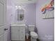Half bathroom features single vanity, toilet, and light purple paint at 1077 Jackson Rd, Fort Lawn, SC 29714