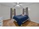 Bright bedroom features queen bed, ceiling fan, laminate wood flooring, and gray curtains at 1077 Jackson Rd, Fort Lawn, SC 29714