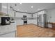 Bright kitchen features white cabinetry, stainless steel appliances, and laminate wood flooring at 1077 Jackson Rd, Fort Lawn, SC 29714