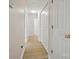 Well-lit hallway featuring light hardwood flooring and white doors at 1162 Willet Dr, Rock Hill, SC 29732