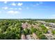 Scenic aerial view of a wooded residential community and skyline in the distance under a partly cloudy sky at 1228 Archdale Dr # H, Charlotte, NC 28217