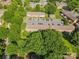 Aerial view of townhomes with parking and surrounded by lush trees at 1228 Archdale Dr # H, Charlotte, NC 28217