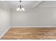 Bright dining space featuring hardwood floors, modern chandelier, and neutral color scheme at 1228 Archdale Dr # H, Charlotte, NC 28217