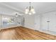 Sunlit dining area featuring hardwood floors, modern chandelier, and neutral walls at 1228 Archdale Dr # H, Charlotte, NC 28217