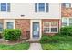 Close-up of a well-kept townhouse entrance with brick facade, garden and manicured lawn at 1228 Archdale Dr # H, Charlotte, NC 28217