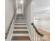 A stairway with wooden stairs and white risers leading to the upper level at 1228 Archdale Dr # H, Charlotte, NC 28217