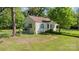 Charming single-story home with yellow siding, brown roof, and lush surrounding trees, nestled in a serene neighborhood at 1302 N Ellis St, Salisbury, NC 28144