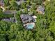 An aerial view reveals the property's mature trees, in-ground pool, outdoor entertaining area and surrounding neighborhood at 13029 Whisper Creek Dr, Charlotte, NC 28277