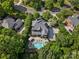 Expansive home is showcased in an aerial view with a swimming pool, lush greenery and neighborhood street at 13029 Whisper Creek Dr, Charlotte, NC 28277