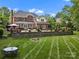 A large backyard with a brick house, a pool, patio area and green lawn perfect for outdoor living at 13029 Whisper Creek Dr, Charlotte, NC 28277