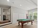 Finished basement with a pool table, neutral colors, and natural light from the window at 13029 Whisper Creek Dr, Charlotte, NC 28277