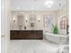 Bright bathroom with a soaking tub, double vanity, stand alone shower and marble floors at 13029 Whisper Creek Dr, Charlotte, NC 28277