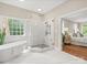 Beautiful bathroom with a soaking tub, stand alone shower, and an open doorway to the bedroom at 13029 Whisper Creek Dr, Charlotte, NC 28277