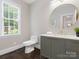 Elegant bathroom with a modern vanity, round mirror, and natural light at 13029 Whisper Creek Dr, Charlotte, NC 28277