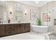 Luxurious bathroom featuring double vanities, a soaking tub, and a glass enclosed shower at 13029 Whisper Creek Dr, Charlotte, NC 28277