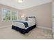 Cozy bedroom featuring a comfortable bed with blue accents and a window offering natural light at 13029 Whisper Creek Dr, Charlotte, NC 28277
