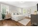 Bright bedroom featuring hardwood floors, a large bed, and natural light from multiple windows at 13029 Whisper Creek Dr, Charlotte, NC 28277