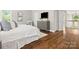 Cozy bedroom with hardwood floors, a dresser, and natural light from a window overlooking the staircase at 13029 Whisper Creek Dr, Charlotte, NC 28277
