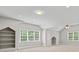 Spacious bonus room featuring natural light, custom built-in shelves, and neutral carpet at 13029 Whisper Creek Dr, Charlotte, NC 28277