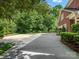 Expansive driveway leading to a well-maintained brick home surrounded by lush greenery and landscaping at 13029 Whisper Creek Dr, Charlotte, NC 28277