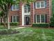Elegant brick facade featuring black shutters, a decorative door, and manicured landscaping on a well-kept lawn at 13029 Whisper Creek Dr, Charlotte, NC 28277