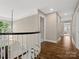 Bright hallway featuring hardwood floors, neutral walls, and an elegant staircase with a decorative light fixture at 13029 Whisper Creek Dr, Charlotte, NC 28277