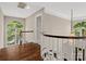Upstairs hallway with hardwood floors, curved railing, and lots of natural light at 13029 Whisper Creek Dr, Charlotte, NC 28277