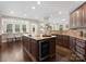 Spacious kitchen with large island featuring a wine cooler and bar seating at 13029 Whisper Creek Dr, Charlotte, NC 28277