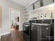 Well-organized laundry room featuring dark washer and dryer and white shelving at 13029 Whisper Creek Dr, Charlotte, NC 28277