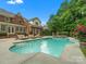 A large in-ground pool with a stone hot tub is highlighted by the home's patio and backyard at 13029 Whisper Creek Dr, Charlotte, NC 28277