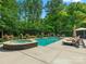 Poolside view of outdoor spa with lounge chairs, umbrella, and manicured flower beds at 13029 Whisper Creek Dr, Charlotte, NC 28277