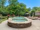 Backyard pool with attached hot tub framed by vibrant flowers and patio lounge area, offering ultimate relaxation at 13029 Whisper Creek Dr, Charlotte, NC 28277