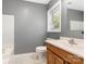 Bathroom featuring a wood vanity, white toilet and tub, and a bright window at 131 Scotland Dr, Mooresville, NC 28115