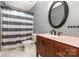 Bathroom showcasing a vanity with granite countertop, oval mirror, and a shower-tub combo at 131 Scotland Dr, Mooresville, NC 28115