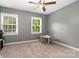 Carpeted bedroom boasting two windows and a ceiling fan, with a small table and chairs at 131 Scotland Dr, Mooresville, NC 28115