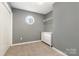 A carpeted bedroom featuring a window, closet space, and a small, white dresser at 131 Scotland Dr, Mooresville, NC 28115