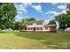 Charming two-story home boasts a spacious yard and inviting curb appeal with red shutters and a screened porch at 131 Scotland Dr, Mooresville, NC 28115