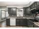 Stylish kitchen featuring black cabinets, granite countertops, stainless appliances, and trendy backsplash at 131 Scotland Dr, Mooresville, NC 28115