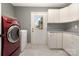 Laundry room with a red washer and dryer, white cabinets, countertop, and view to exterior at 131 Scotland Dr, Mooresville, NC 28115