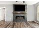 Living room showcasing a stone fireplace with electric insert, hardwood floors, and gray walls at 131 Scotland Dr, Mooresville, NC 28115