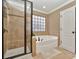 Well-lit bathroom with a tiled shower, separate soaking tub, and modern fixtures at 14837 Dungannon Ct, Charlotte, NC 28278