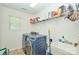 Bright laundry room features modern washer and dryer, storage shelves, and a utility sink at 14837 Dungannon Ct, Charlotte, NC 28278