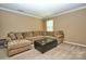 Living room with comfortable sectional sofa and ottoman, perfect for relaxing at 14837 Dungannon Ct, Charlotte, NC 28278